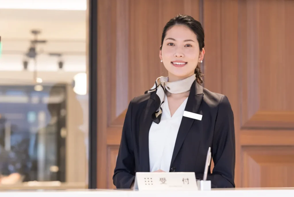 ホテルのフロントに立つ制服姿の女性スタッフ