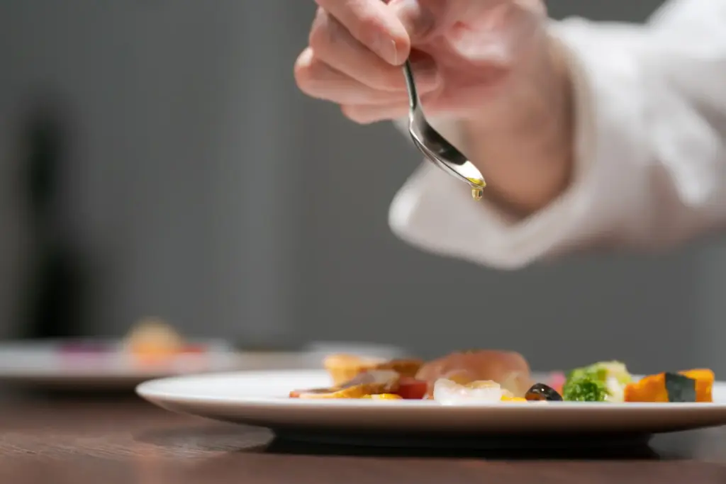 料理の盛り付けをする男性シェフの手元
