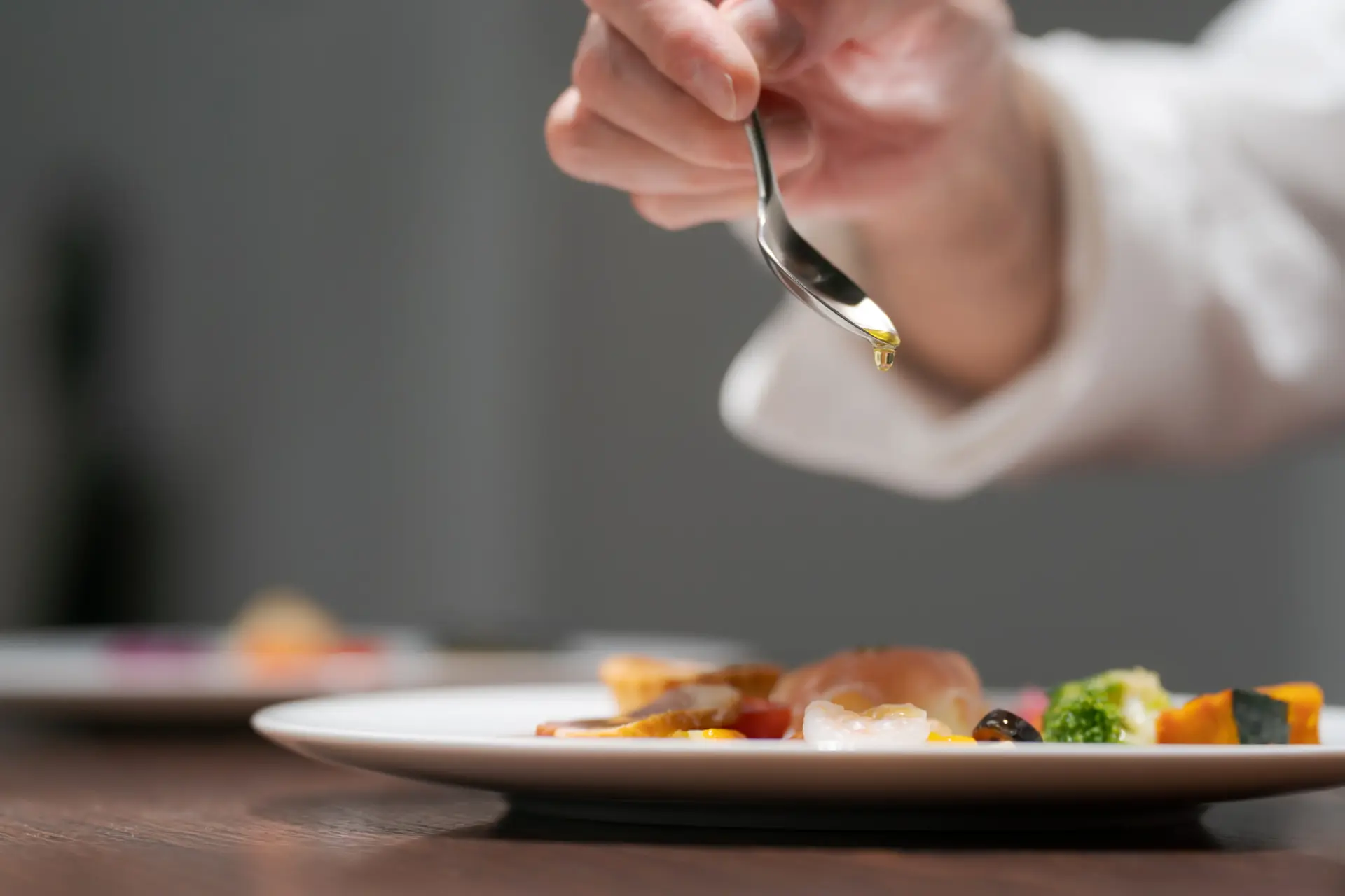 料理の盛り付けをする男性シェフの手元