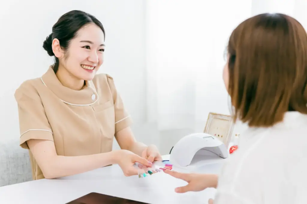 ネイルチップを使ってカラーとデザインのカウンセリングをするネイリスト